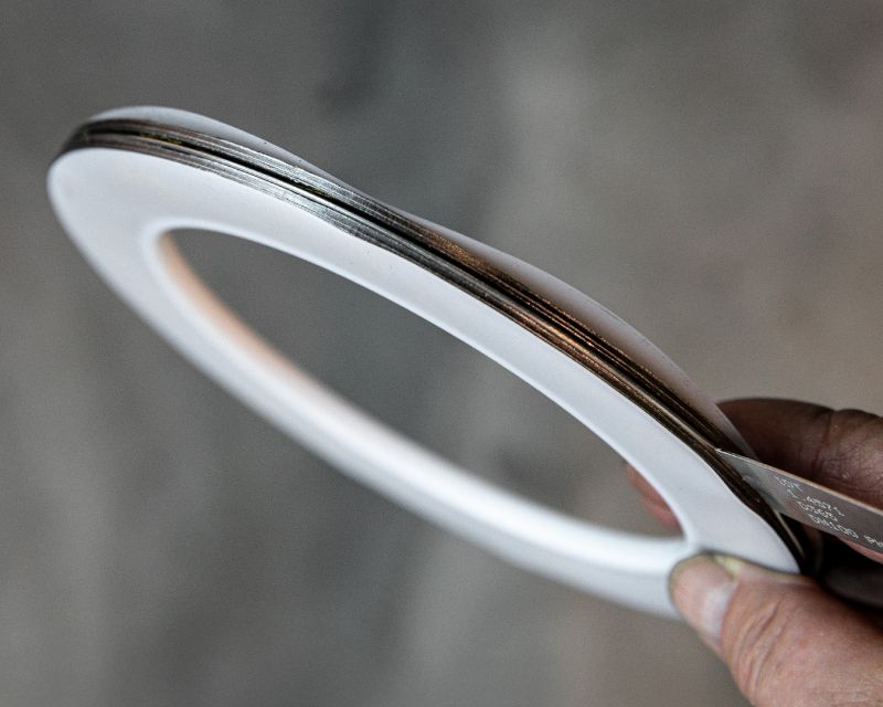 Hand hält eine ringförmige PTFE-Flachdichtung mit metallischer Kernlage in die Kamera
